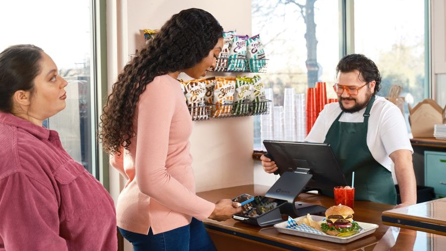 Customers paying at a counter with a point-of-sale terminal