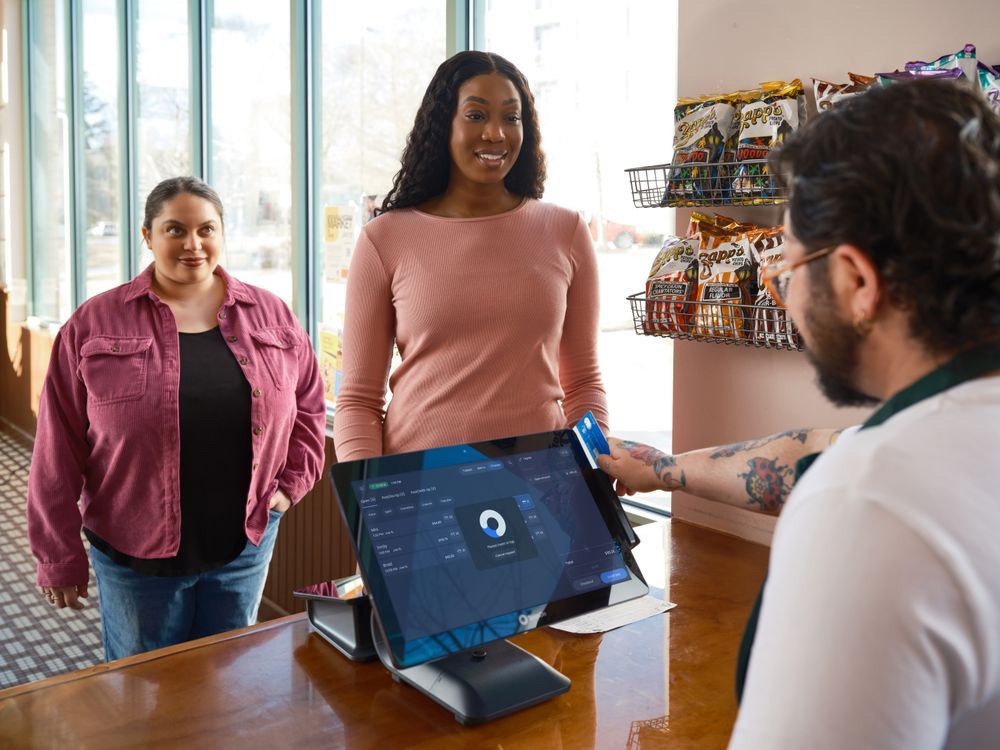 A cashier helping customers at a boutique counter